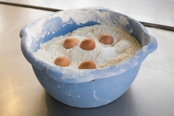 Eggs in bowl of flour