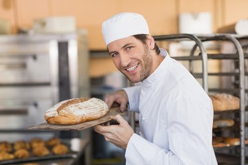 Smiling baker smelling fresh bread