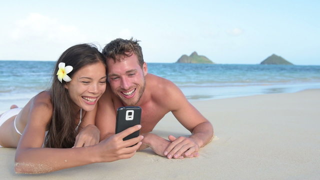 Smart phone - beach holiday couple taking selfie