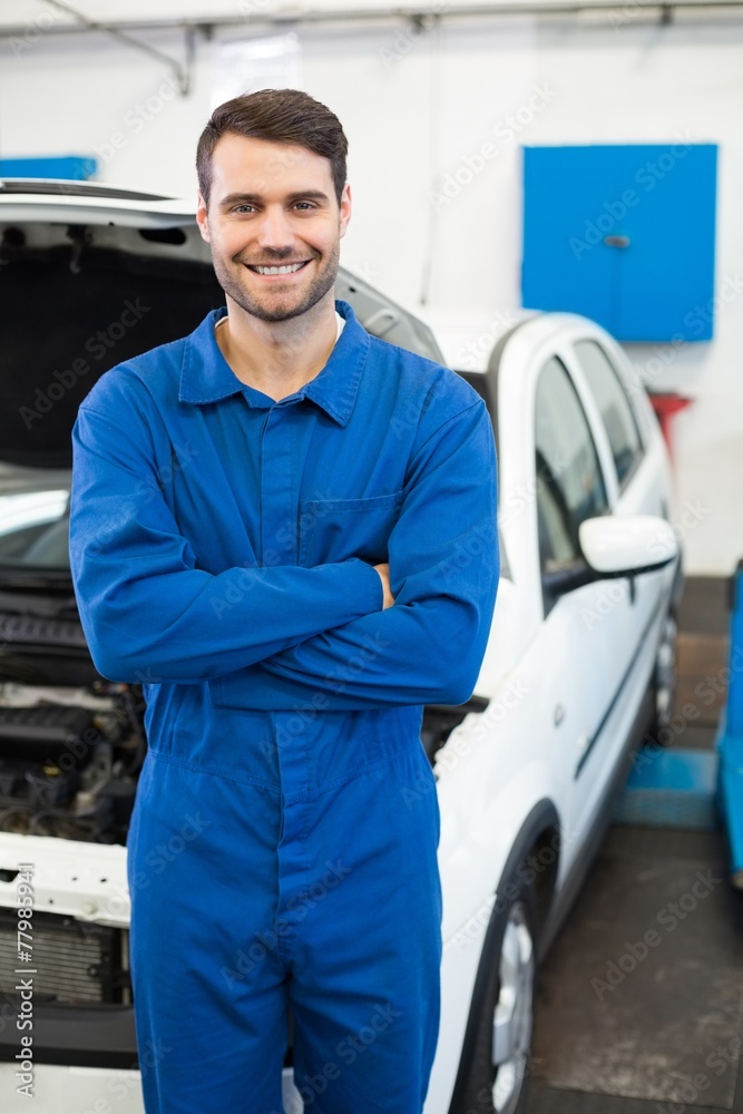 Poster smiling mechanic looking at camera