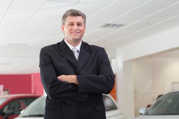 Smiling businessman standing with arms crossed