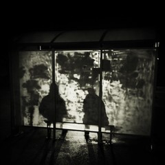 silhouette of two person waiting for the bus in the night