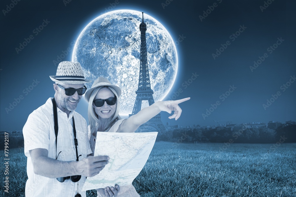 Aufkleber Composite image of happy tourist couple using map and pointing