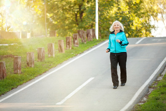 Senior Woman Jogging At The Pedestrian Walkway