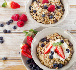 Muesli,  fresh berries and yogurt for  breakfast  on a wooden ta
