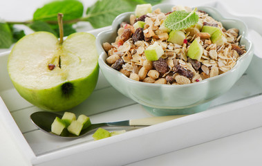 Muesli and green ripe apple for healthy breakfast.