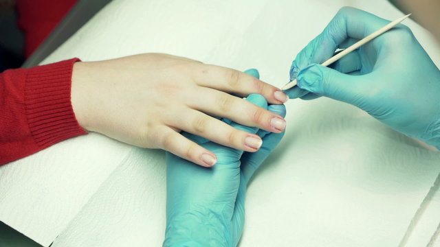 Close up of manicurist preparing fingernails at beauty salo