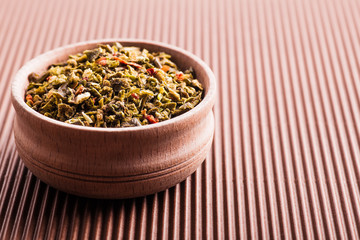 dry spice green pepper in a wooden bowl