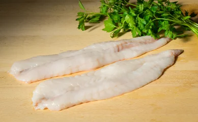 Türaufkleber Monkfhis or Angler fish fillets on a wooden cutting board © Angela Bragato