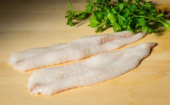 Monkfhis or Angler fish fillets on a wooden cutting board