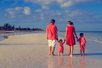 Young family with two kids walking at beach