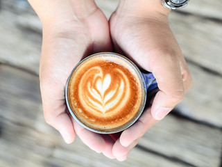 man holding hot cup of coffee latte art, coffee lover concept.