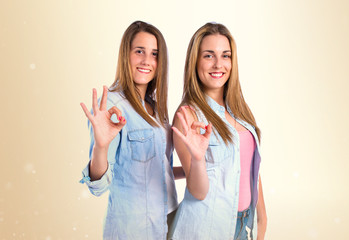 Friends making Ok sign over white background