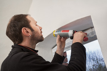 Carpenter mounting a new window