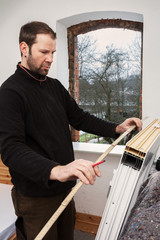 Carpenter mounting a new window