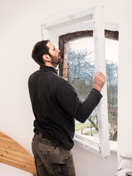 Carpenter mounting a new window