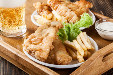 Fish and chips with tartar sauce on a tray
