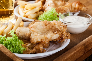 Fish and chips with tartar sauce on a tray