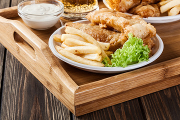 Fish and chips with tartar sauce on a tray