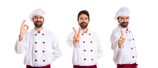 Chef doing victory gesture over white background