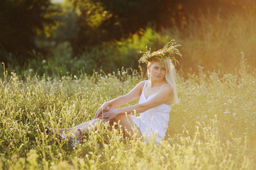 Fototapeta na wymiar Ukrainian girl in a white sundress with a wreath of flowers on h