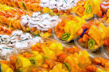 Many different fruit salads for sale at a market