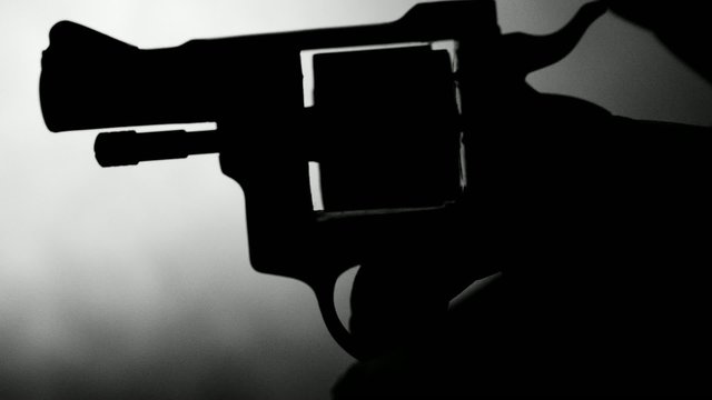 Silhouette of a mans hand with a handgun,real time