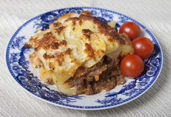 Moussaka with potatoes, minced meat, tomatoes, onions and garlic