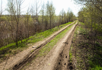 Obraz premium Empty countryside road through fields with wheat