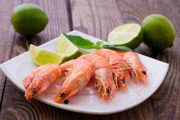 Delicious fresh seafood shrimp with lime on wooden table