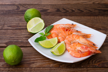 Delicious fresh seafood shrimp with lime on wooden table