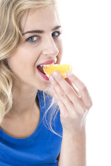 Model Released.  Young Woman Eating an Orange Segment