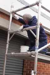 A painter working from a scaffold tower