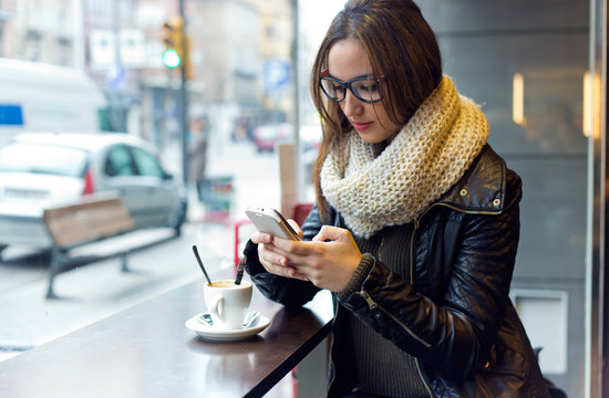 Beautiful Girl Using Her Mobile Phone In Cafe.