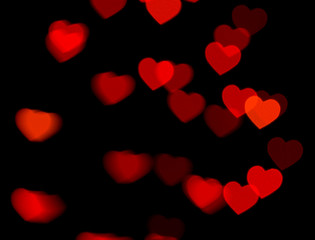 Fototapeta na wymiar red heart bokeh on dark background