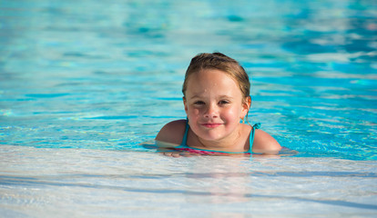 Fototapeta na wymiar Cute little girl in the swimming pool