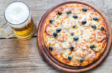 Cooked pizza with a glass of beer