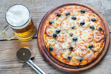 Cooked pizza with a glass of beer