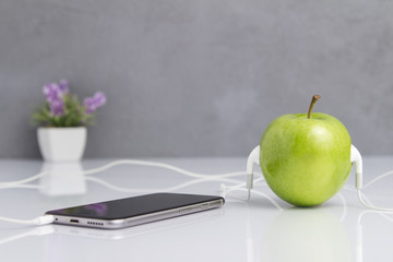 Green Apple with Headset Connected to Phone