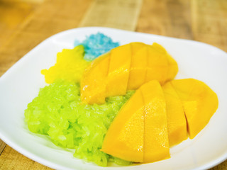 colorful sticky rice on sweet ripe mango dipping by coconut milk