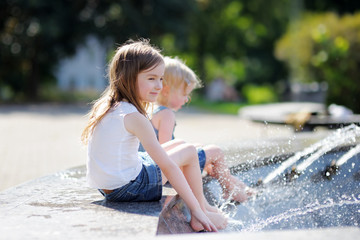 Two sisters having fun in a fountain