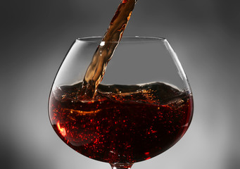 Red wine pouring into wine glass, close-up