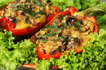 Stuffed red peppers with greens on on lettuce close up
