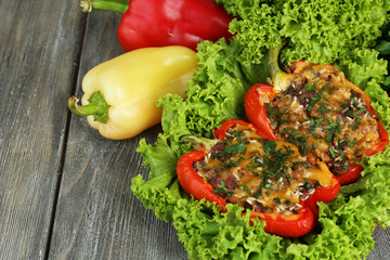 Stuffed red peppers with greens and vegetables on table close