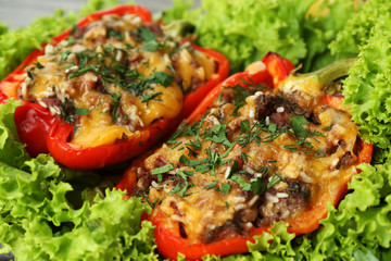 Stuffed red peppers with greens on on lettuce close up