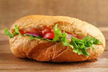 Sandwich with salmon on wooden background