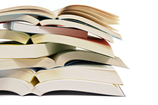 Untidy stack or pile of colorful paperback books isolated white background photo