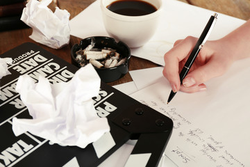 Female hand writing script at desktop with moving clapper and