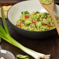 Guacamole with green onions and nachos. Selective focus.