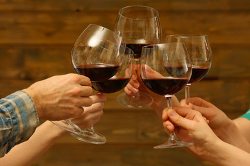 Clinking glasses of red wine in hands